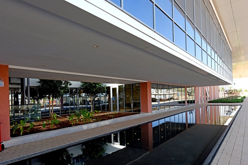 Reflecting pool mirroring the glazed upper level and planted courtyard beneath the cantilevered building volume