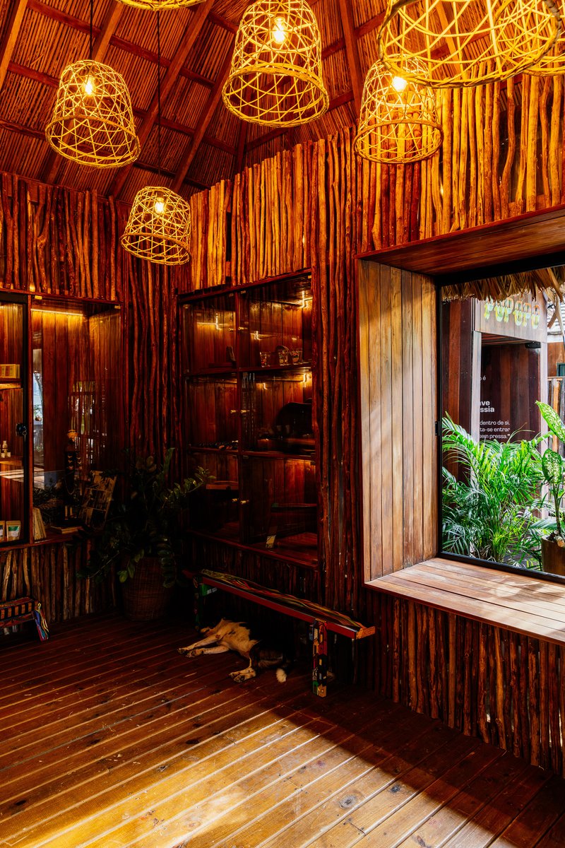 Interior with bamboo walls and woven pendant lights hanging above a timber deck floor
