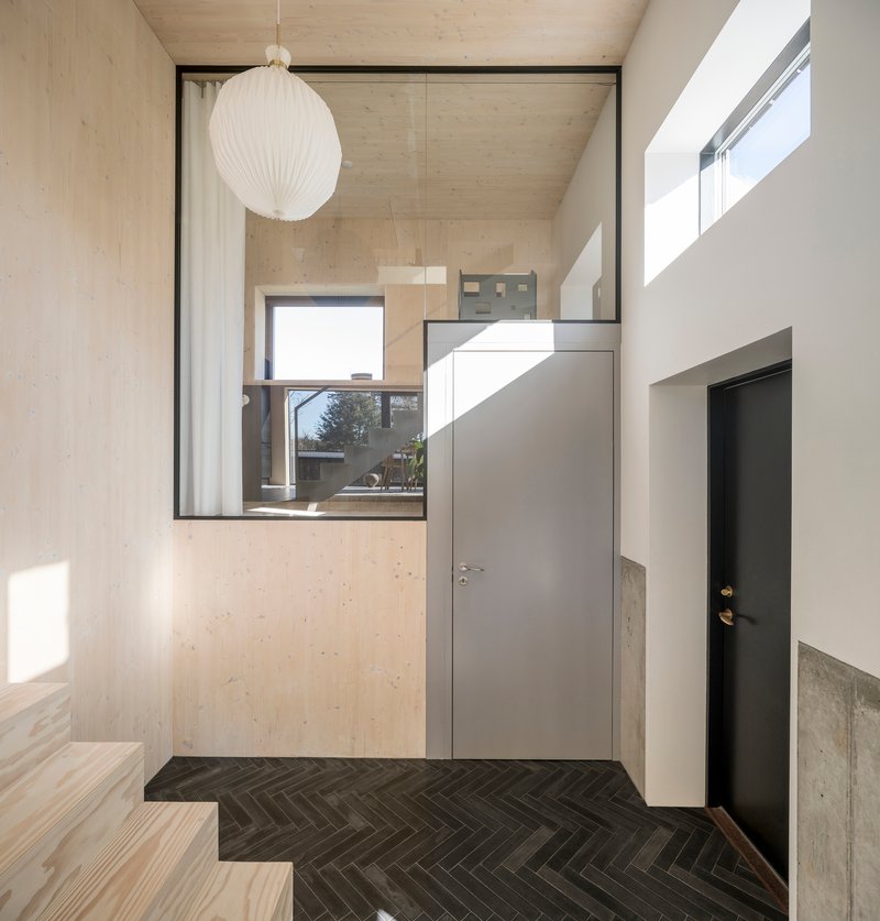 Entry hall with herringbone tile floor and grey doors beneath a spherical pendant lamp