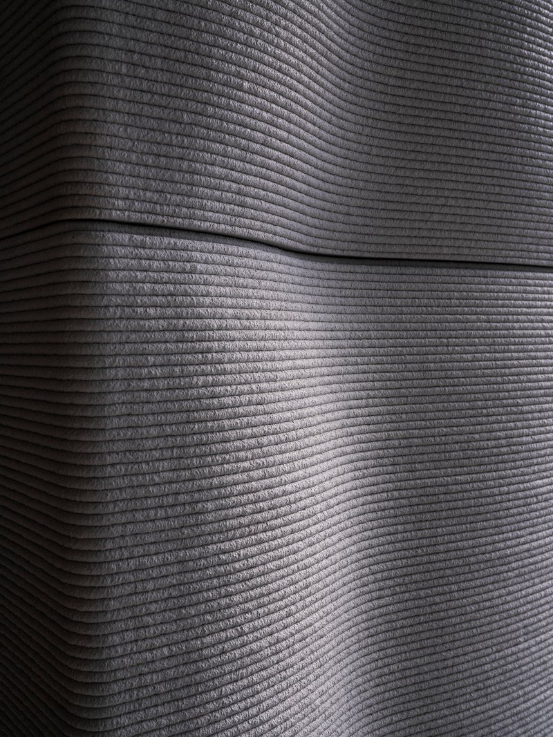 Horizontally striated concrete wall surface with recessed shadow line in raking light