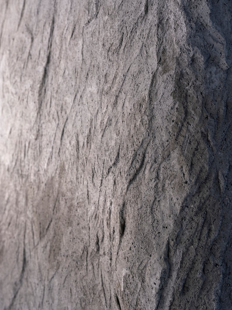 Close-up of textured concrete surface with vertical formwork markings and natural weathering