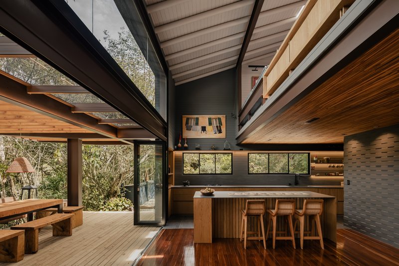 Kitchen with timber island, open shelving and glazed connection to covered outdoor dining terrace