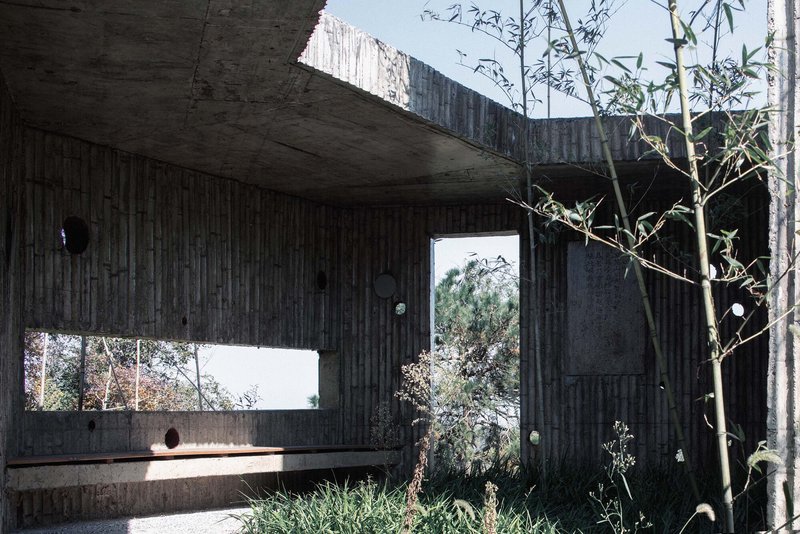 Covered terrace with ribbed concrete ceiling and horizontal window framing the hillside beyond