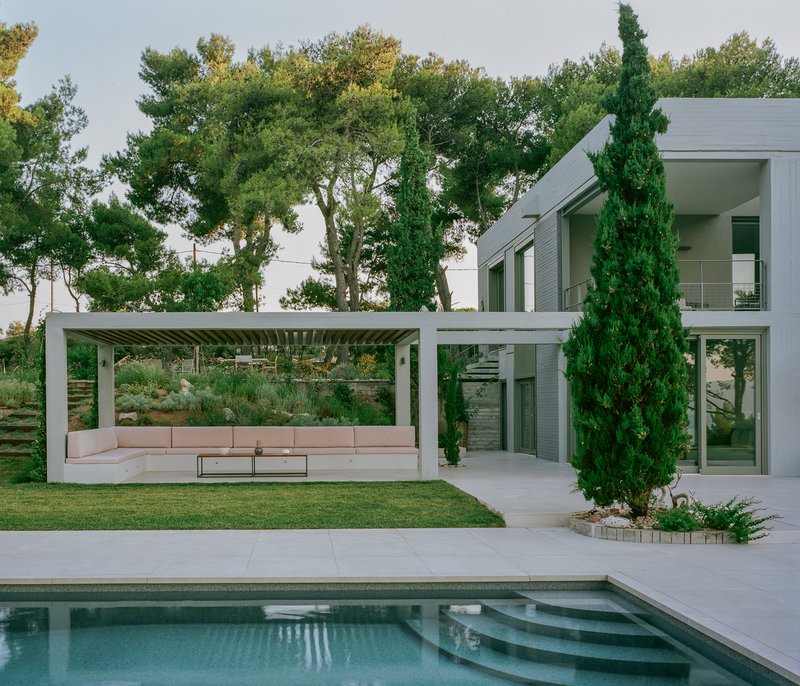 Covered terrace with pink cushioned seating and slatted timber ceiling beside the swimming pool
