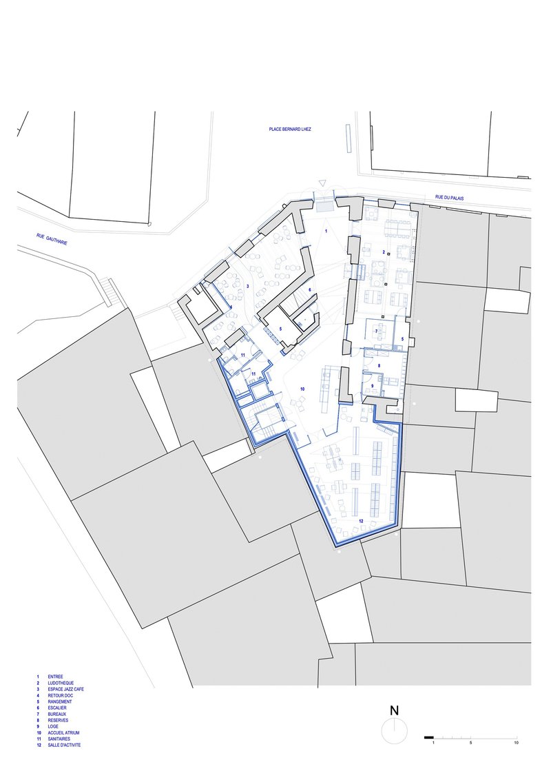 Floor plan drawing showing rooms arranged along angled streets with adjacent buildings in grey