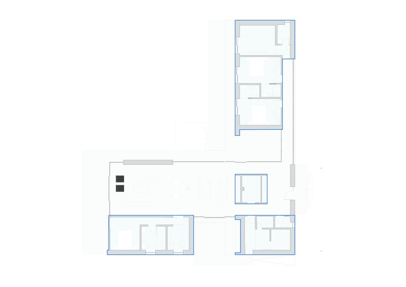 Floor plan drawing showing an L-shaped residence with clustered service rooms in one wing and open living space