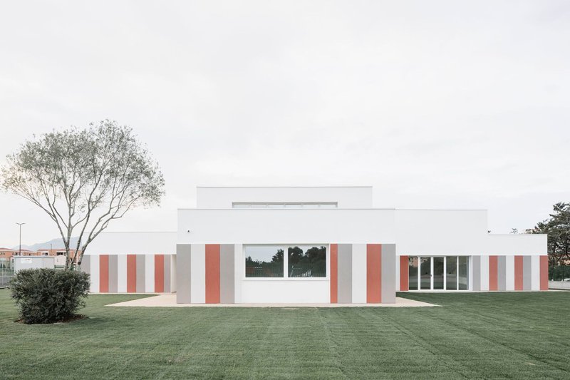 Side elevation showing the staggered white volumes with terracotta panels and a tree at left