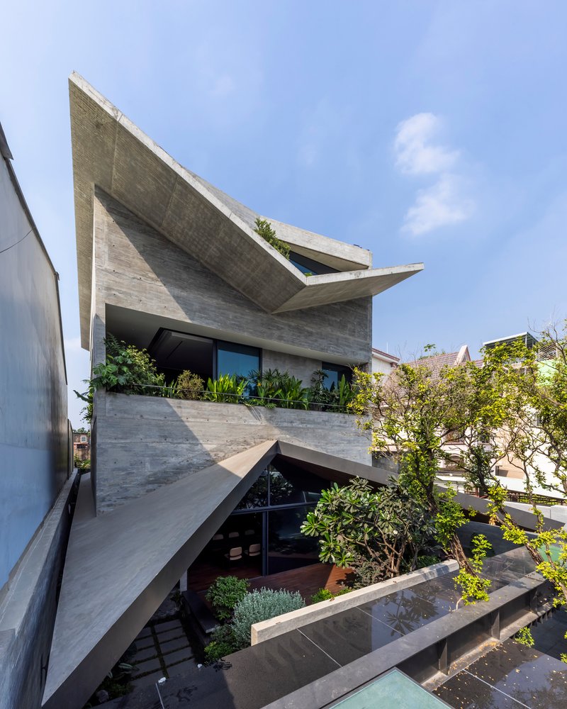 Angled view of the cantilevered concrete slabs with integrated planters and glazed openings below
