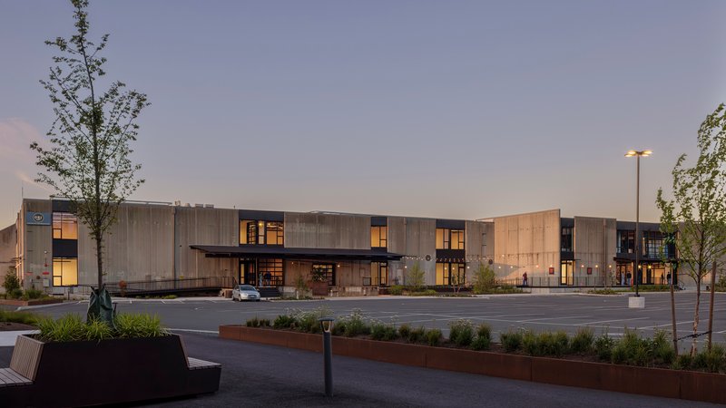Long view of the corrugated metal facade across the parking lot at dusk