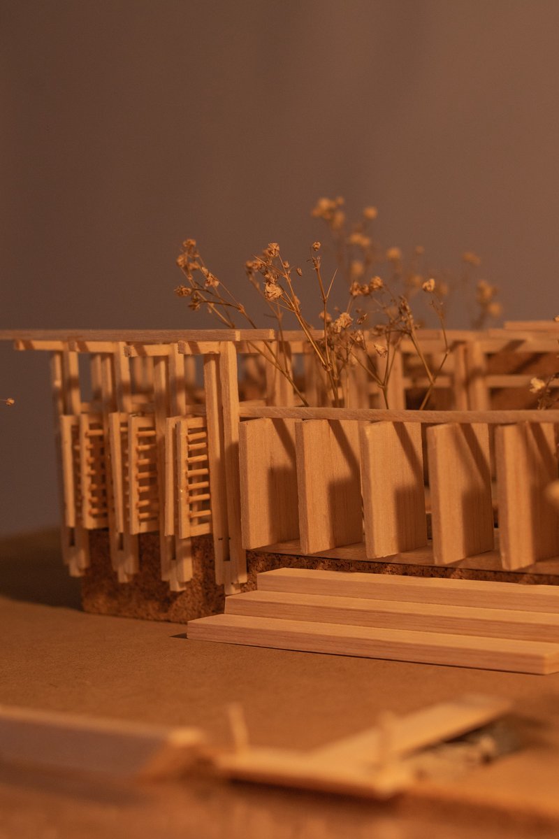 Close-up of the physical model showing dried flower stems among the timber frame members