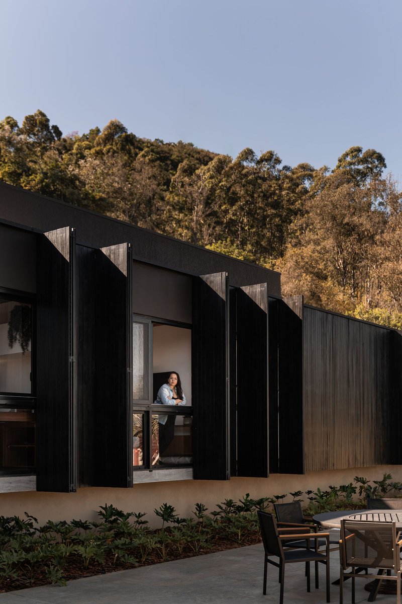 Accordion folding doors opening to a courtyard with a person framed in the threshold