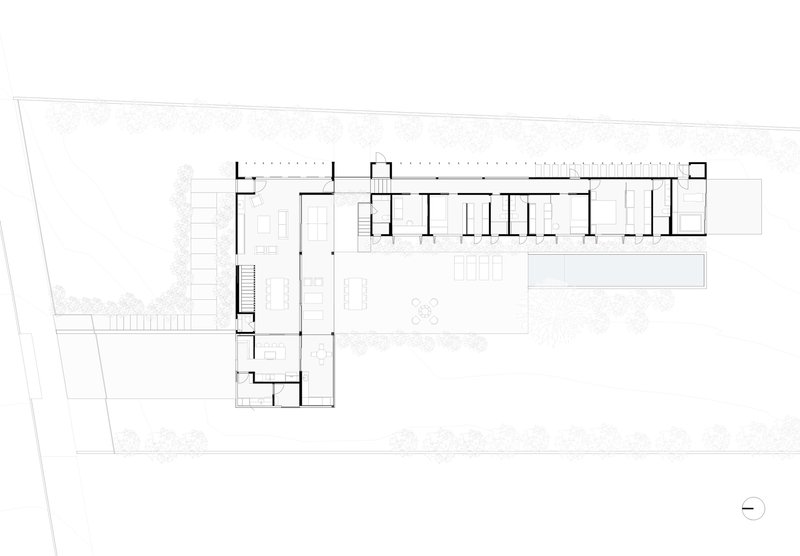 Ground floor plan drawing showing an L-shaped layout with a long linear wing and planted courtyard