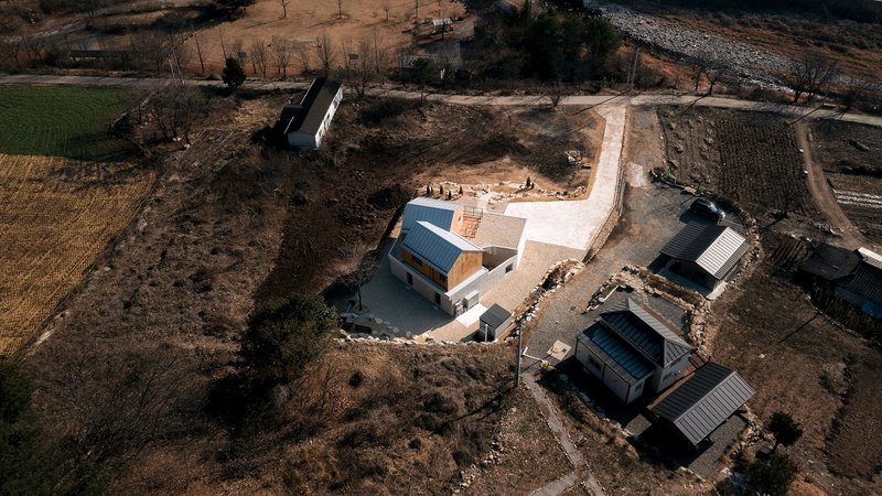 Aerial view of the compound showing the main house and two smaller outbuildings in the landscape
