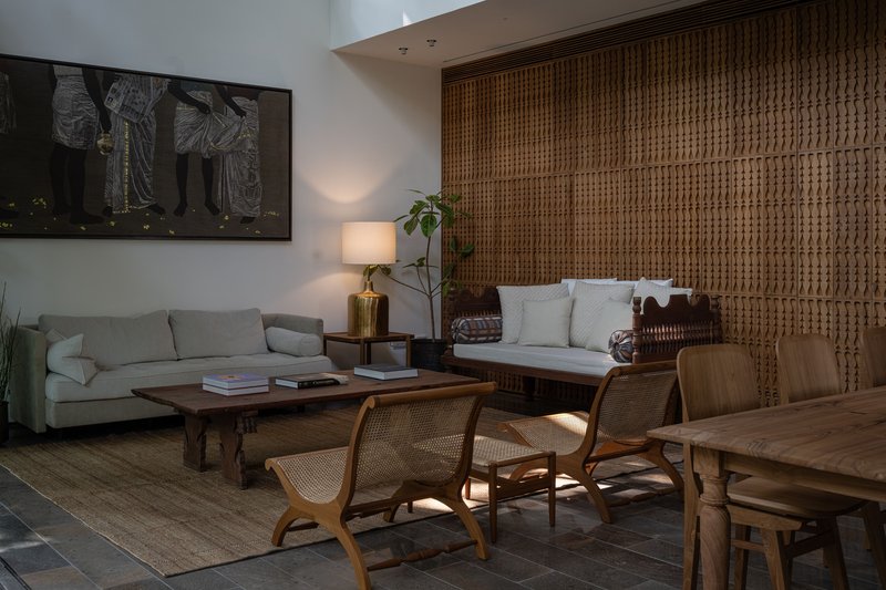 Living area with woven rattan wall panel and sunlight filtering through a window