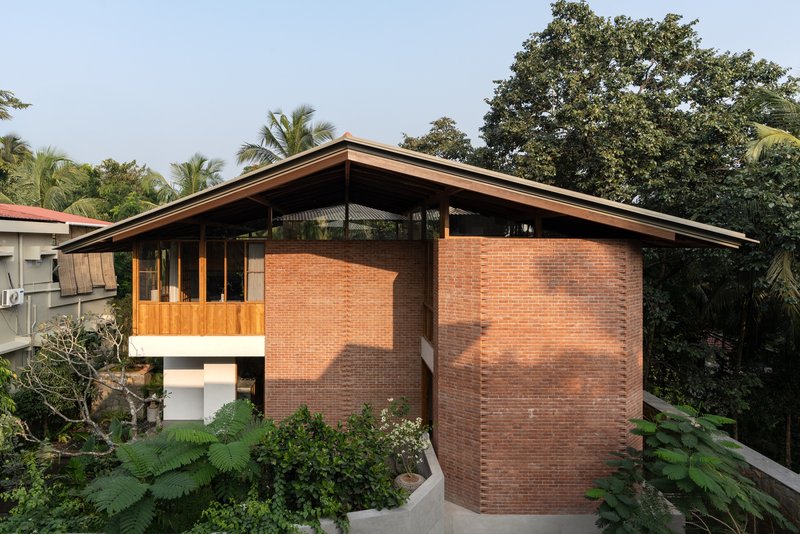 Side elevation showing the cylindrical brick volume and pitched roof with exposed timber structure