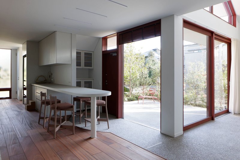Kitchen and dining area with terrazzo floor threshold and tall mahogany door frames to garden