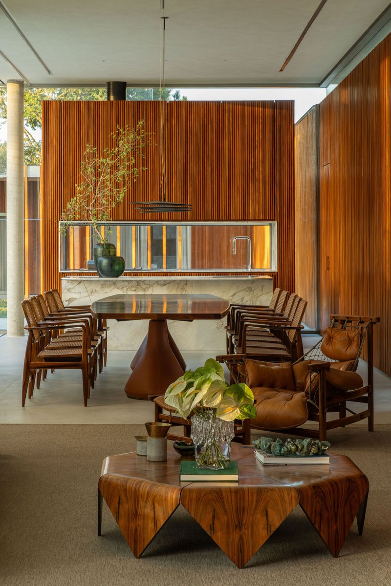 Dining area with illuminated marble-topped bar backed by vertical timber slats and foliage