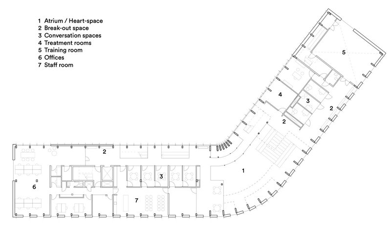 Floor plan drawing showing an angled wing with treatment rooms and offices wrapping around a central atrium