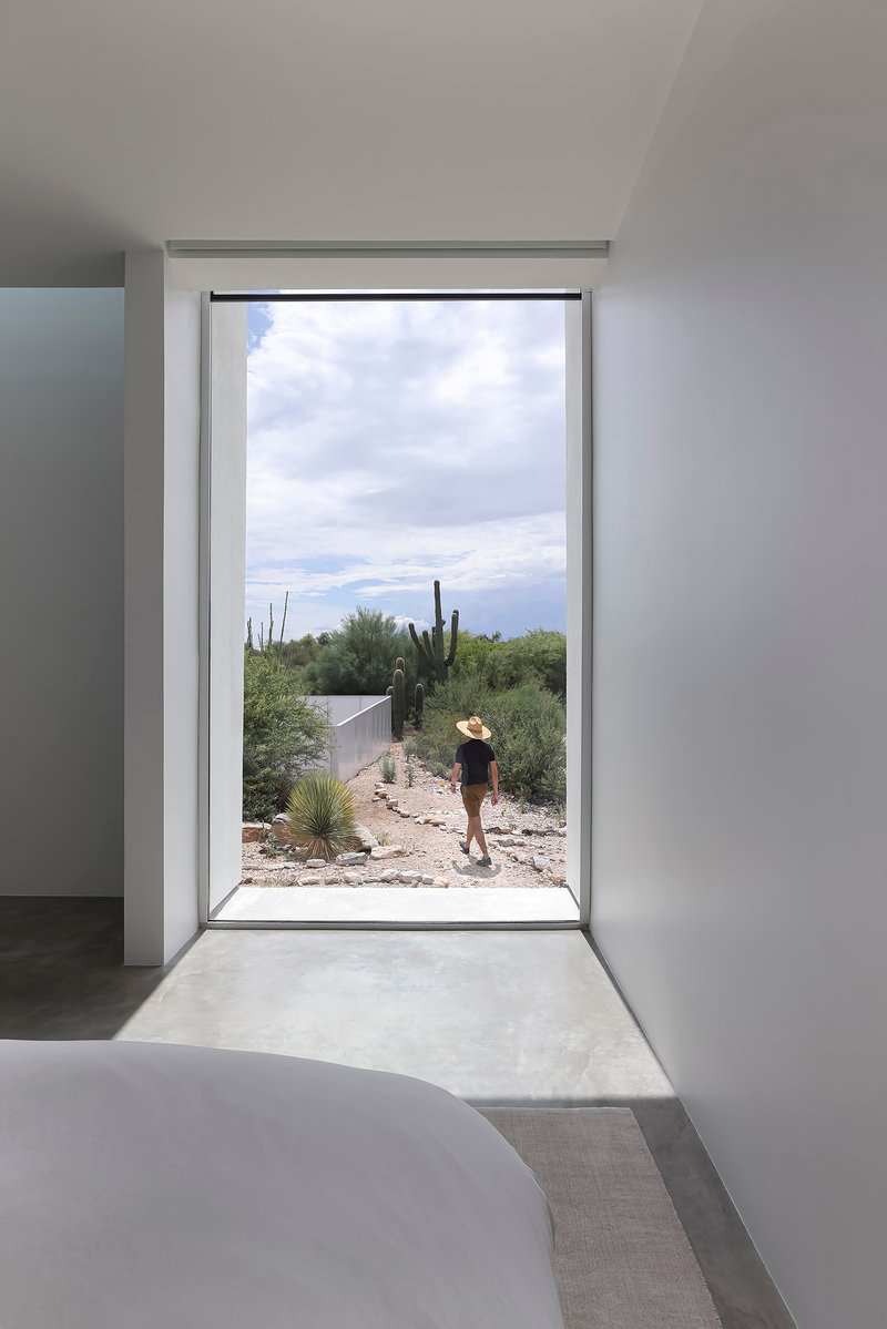Interior doorway framing a figure in the desert landscape with cacti visible in afternoon light