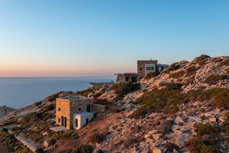Distant view of stone structures on the coastal slope at sunset overlooking the sea