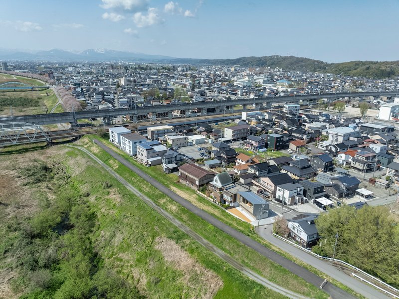Aerial view of residential neighborhood with elevated highway and distant mountains under clear skies