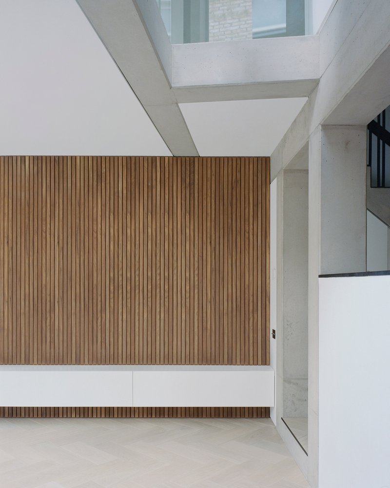 Top-down view of vertical timber slat wall with exposed concrete beams and skylight above