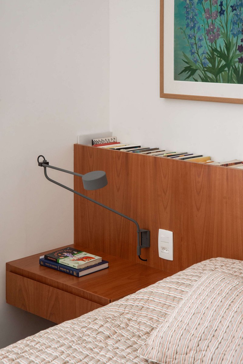 Close-up of timber headboard with integrated nightstand and articulated reading lamp