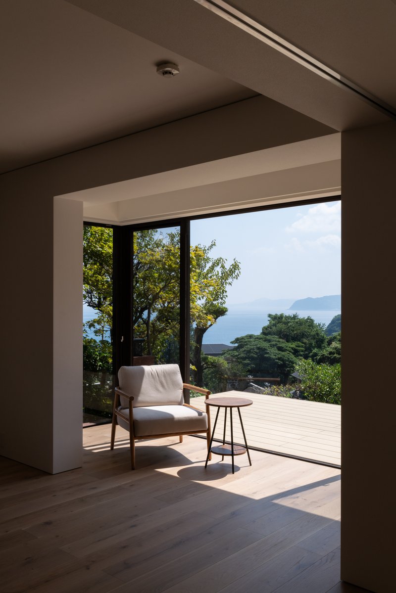 Framed opening from interior room to terrace deck overlooking lush hillside and distant ocean