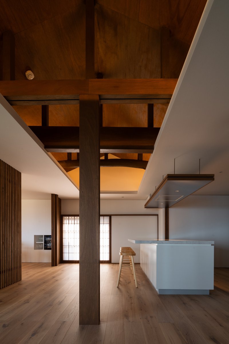 Kitchen island beneath timber post-and-beam structure with translucent sliding screens in the background