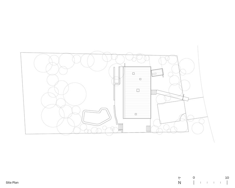 Site plan drawing showing a rectangular building with pool, deck, and landscaping with circular tree canopies