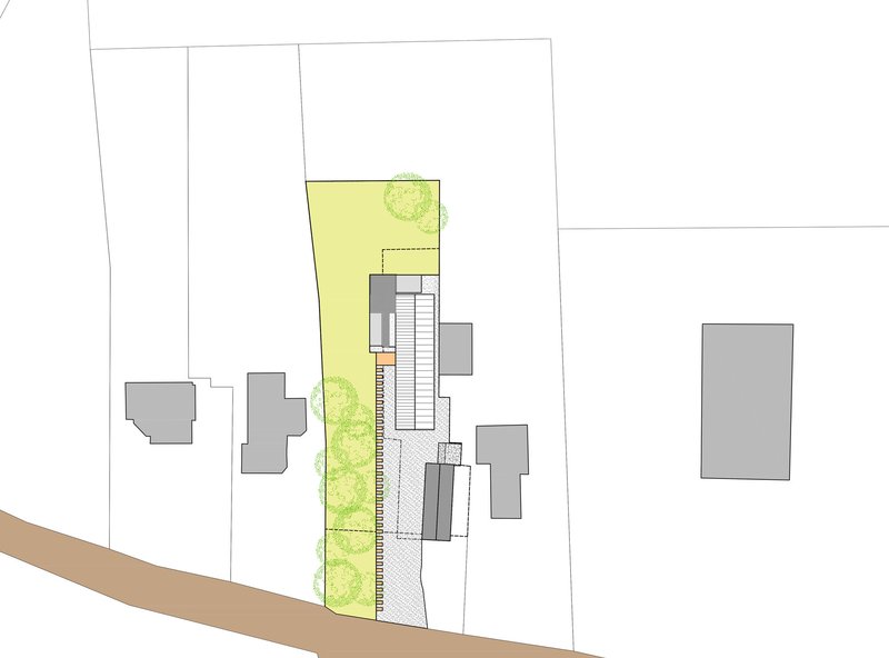 Site plan drawing showing a narrow residence with green landscaped areas along a diagonal street