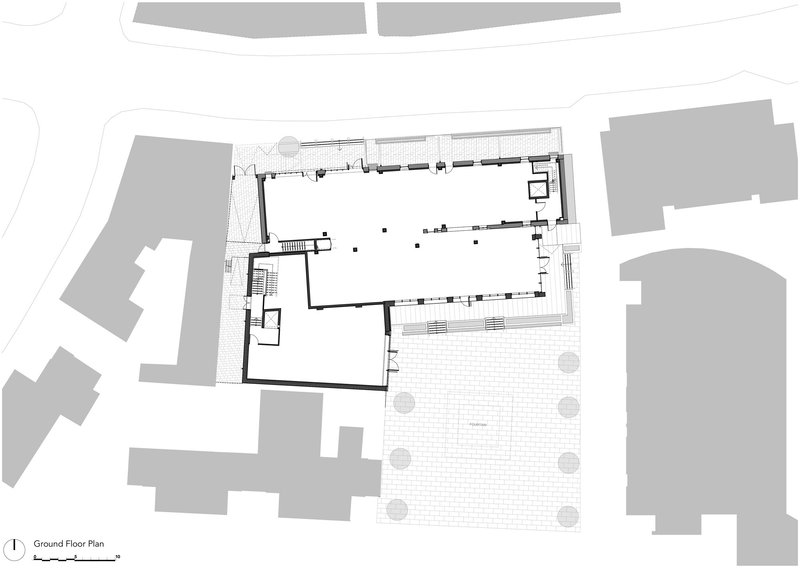 Ground floor plan drawing showing L-shaped volume wrapping courtyard with paved surface and trees