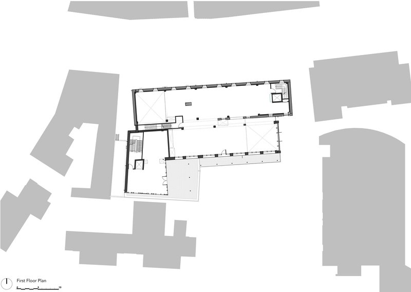 First floor plan drawing showing two rectangular halls connected by circulation core and stair