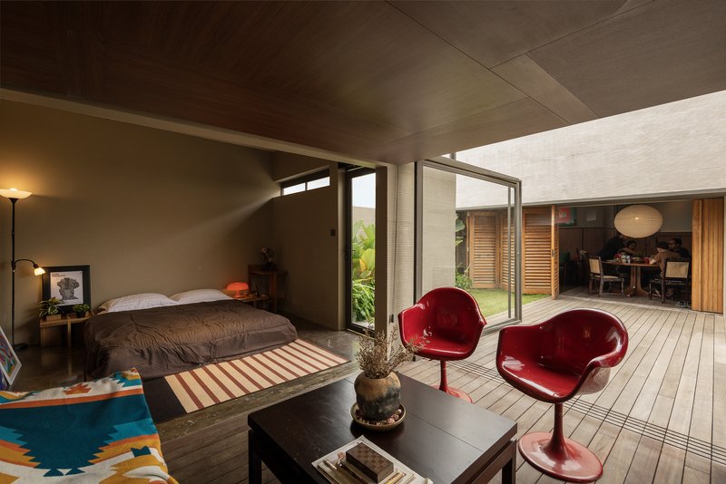 Bedroom opening onto timber deck with clerestory windows and slatted wood ceiling bathed in natural light