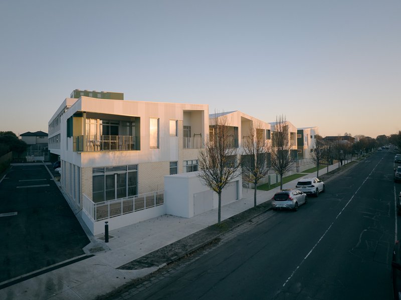 Elevated view of the residential street at dusk with parked cars and young street trees