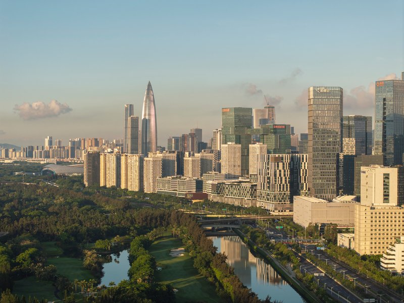 Aerial view of the tower skyline with parkland and canal in the foreground at golden hour