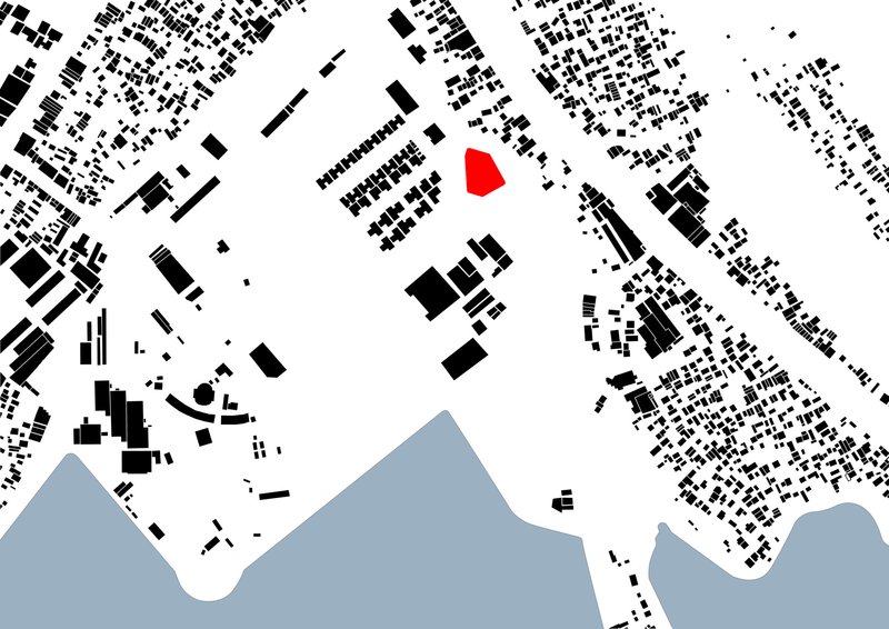 Site plan drawing showing a red-highlighted building footprint among black building masses and a waterfront