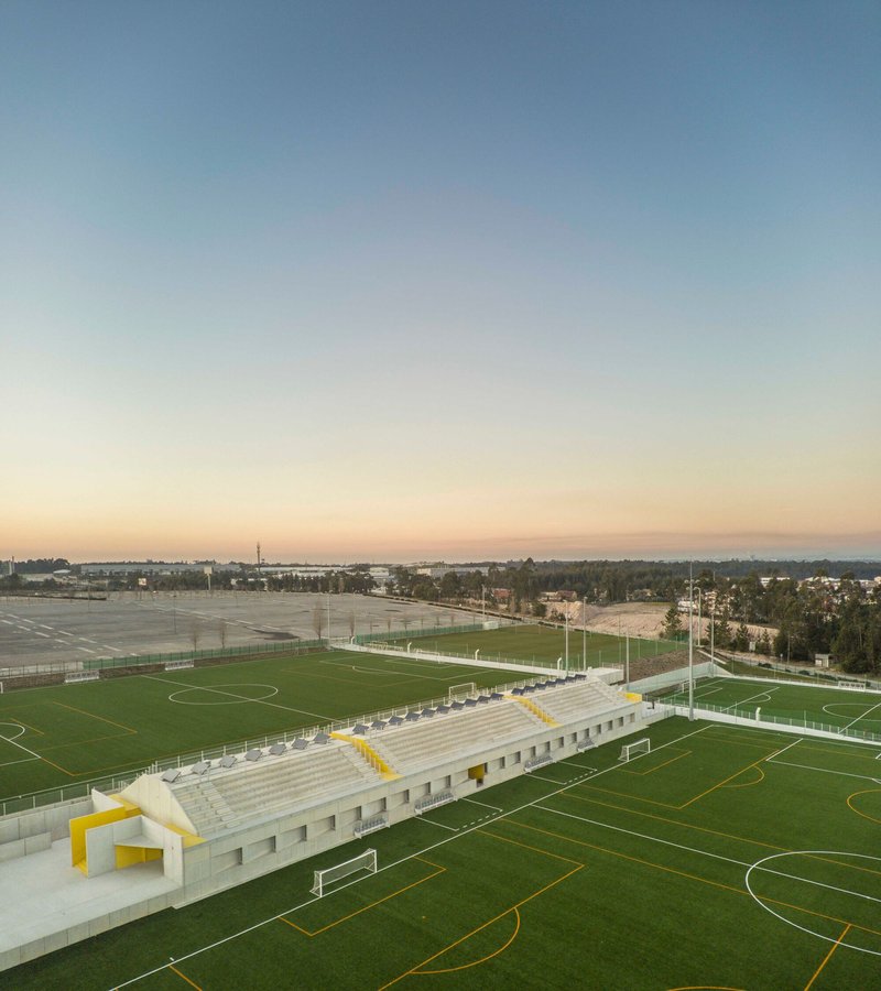 Elevated view of the canopy structure and tiered seating overlooking multiple sports fields at dusk