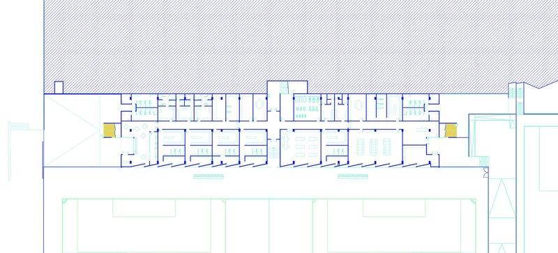 Floor plan drawing showing the linear grandstand building with symmetrical rooms and yellow circulation cores