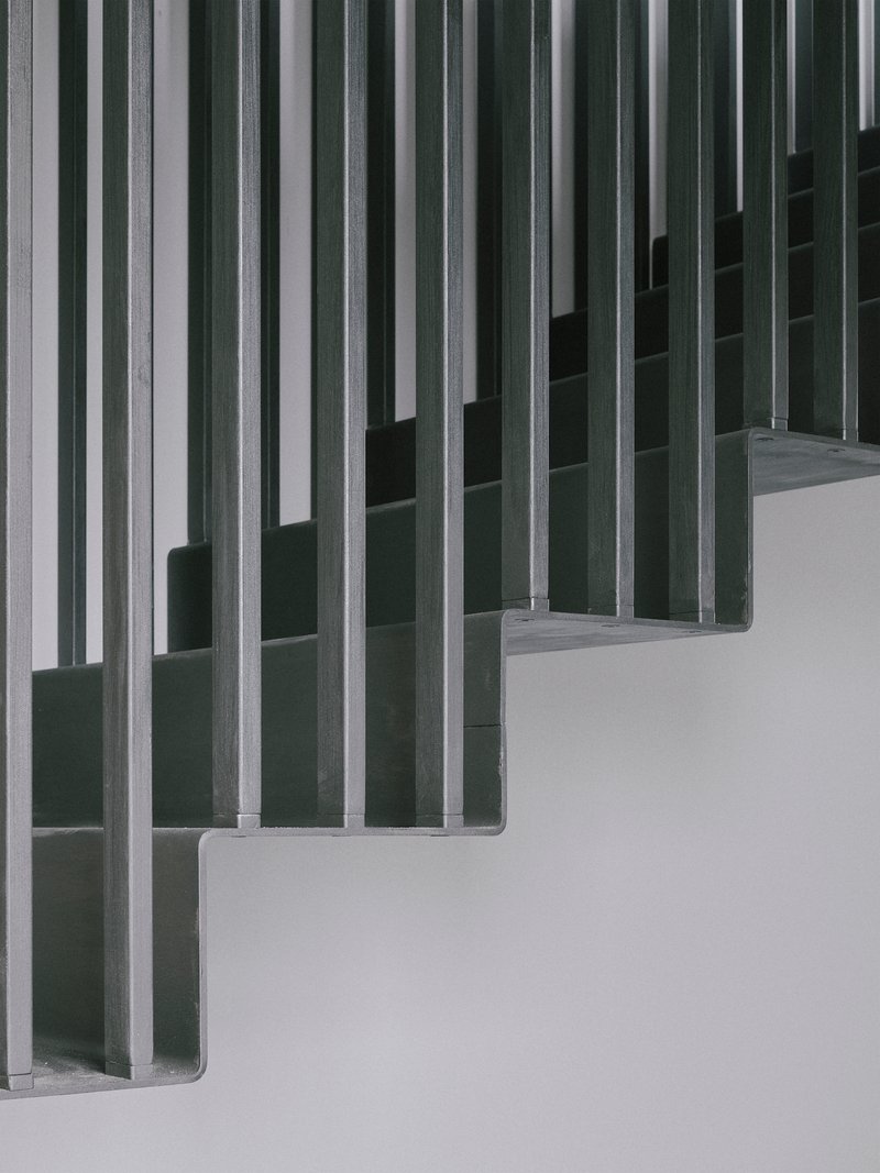 Close-up of vertical timber slat screens forming a rhythmic pattern against a white wall