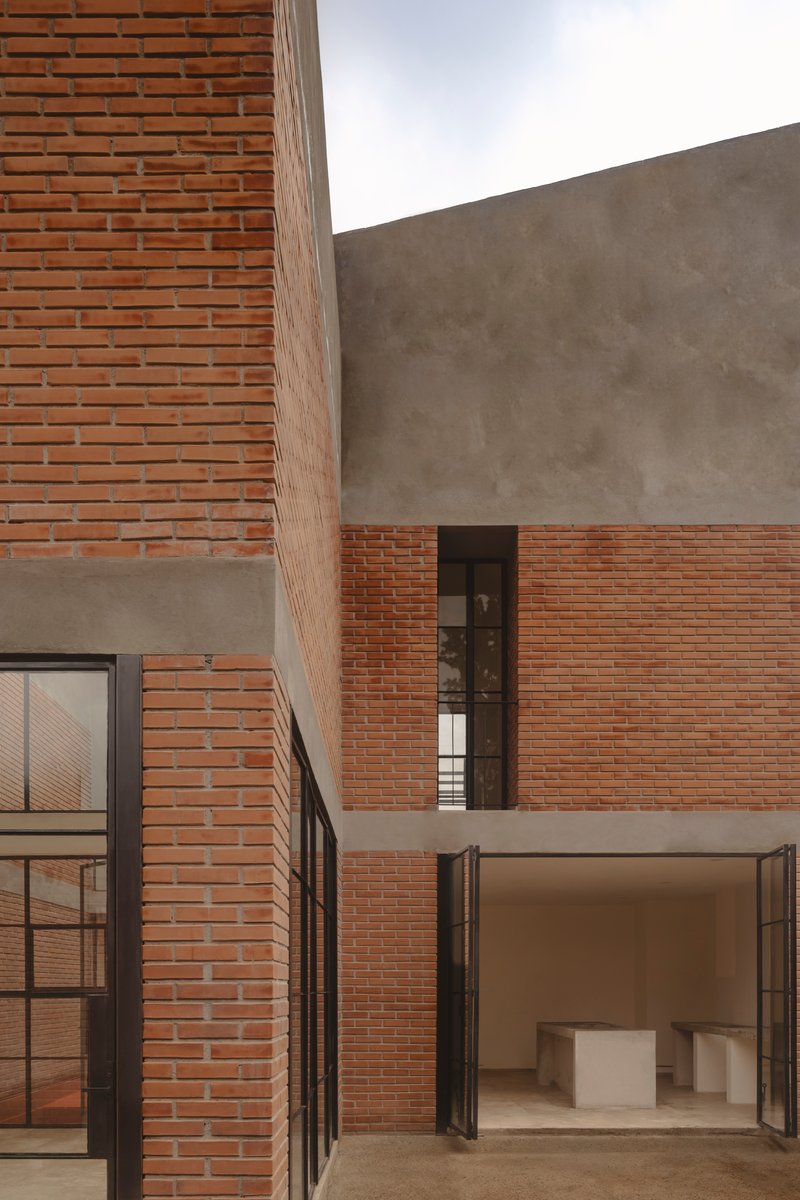 Interior courtyard showing interlocking brick and concrete volumes under diffused daylight