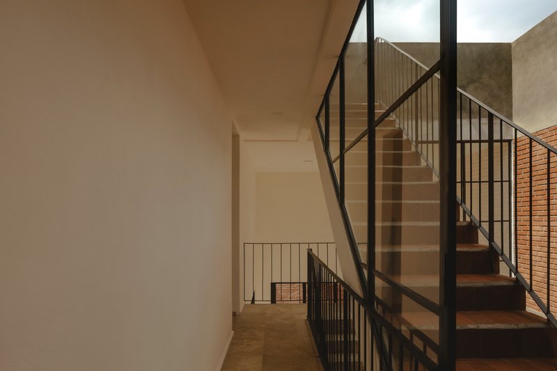 Interior view of concrete stairs with black metal railings and glass panels in soft daylight