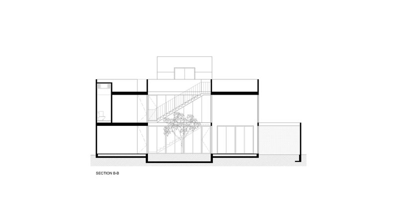 Section drawing showing split-level interior volumes with a central staircase and planted courtyard