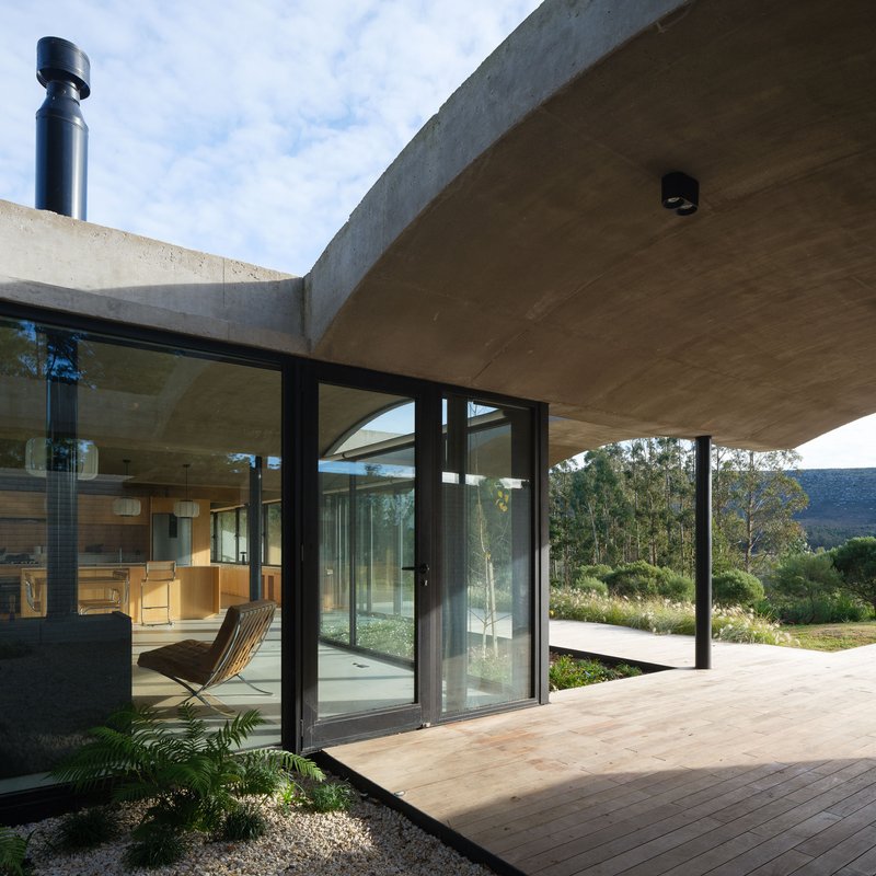 Timber deck terrace with sliding glass doors opening to a landscape of distant hills