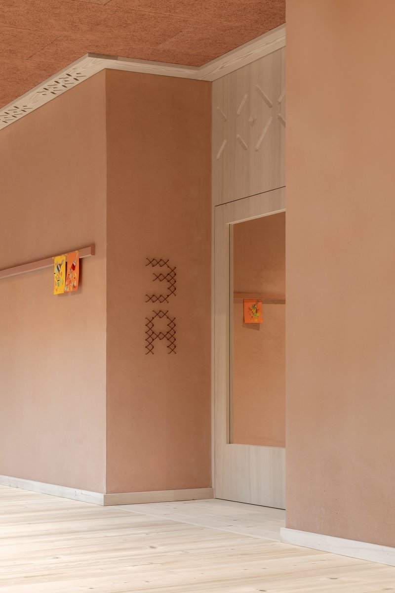 Interior corner with plywood walls, a small mirror, and terracotta ceiling illuminated by soft natural light