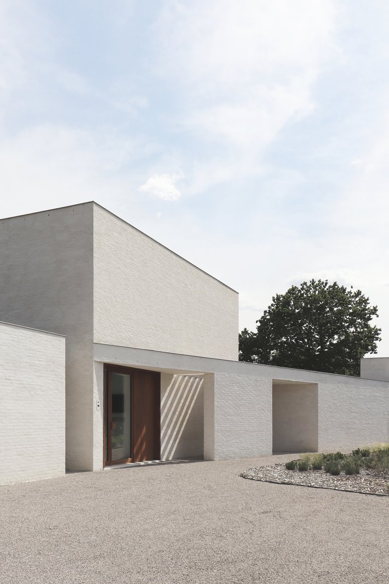 Street-facing elevation showing timber entry door set in white and grey brick walls