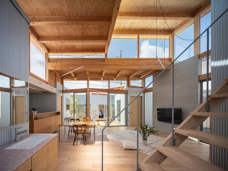 Interior view through the timber frame structure showing layered ceiling planes and clerestory glazing above