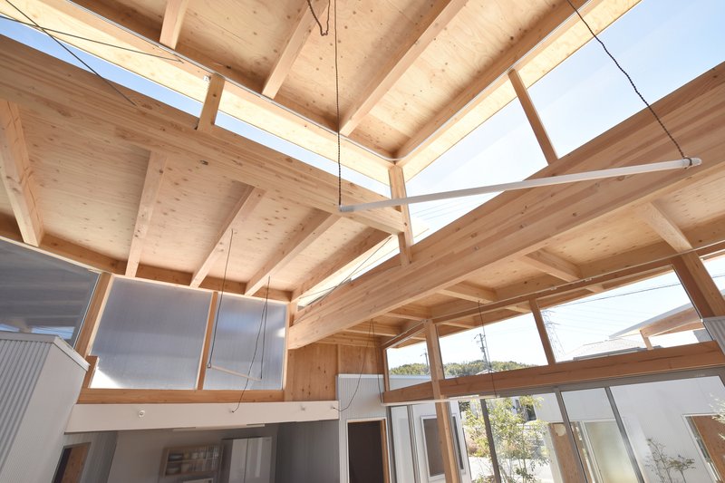 Upward view of the exposed timber ceiling structure with clerestory windows admitting daylight