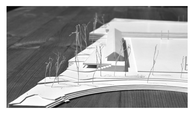 Physical model showing white volumes with wire trees alongside a curved landform base