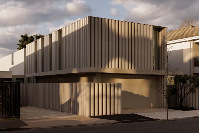 Corner view of the two-story residence with vertical timber slats wrapping the facade